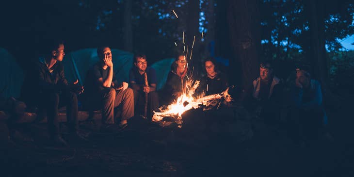 a group of campers around a campfire.