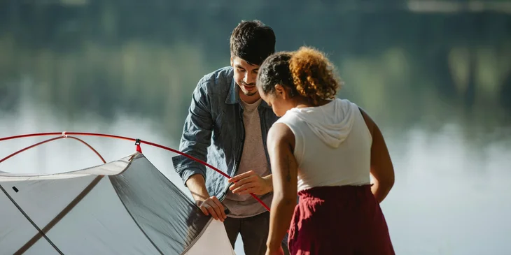 A camp leader helping on putting up a tent.