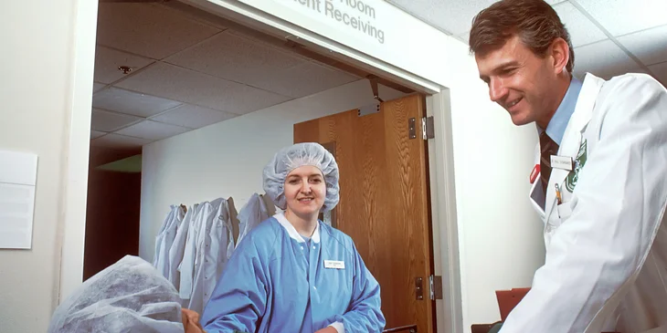 A cardiologist talking to a patient outside the recovery room.