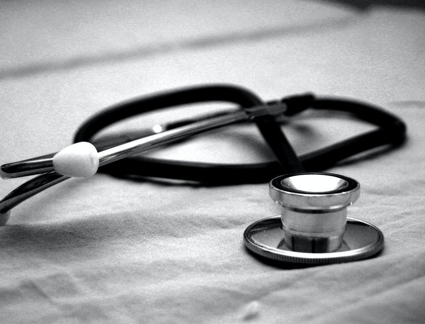A cardiology technician's black and gray stethoscope on a white paper.