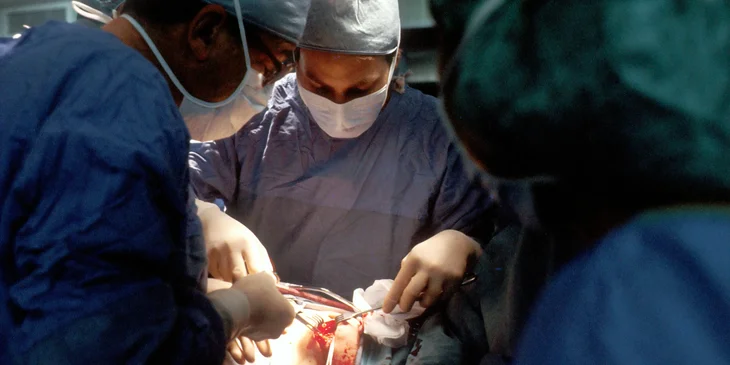 A cardiothoracic surgeon performing a surgery to an old patient.