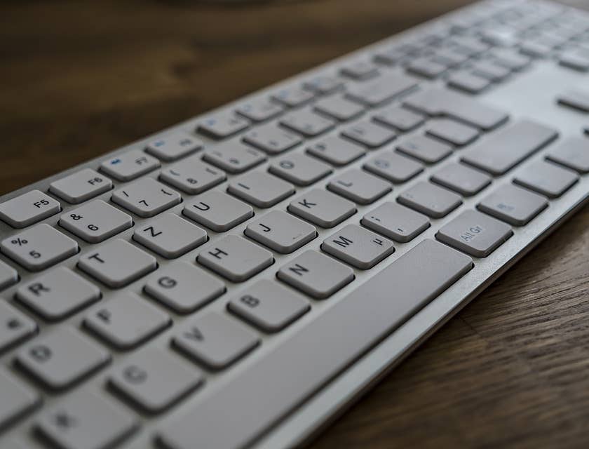 A white keyboard on a wooden surface.