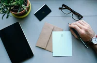 Un jefe escribiendo una carta de agradecimiento profesional para sus empleados más destacados.