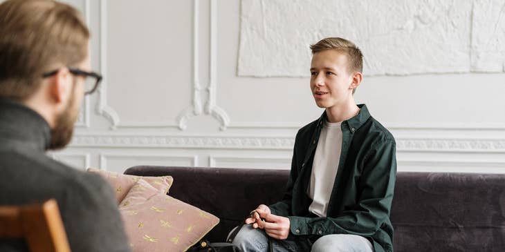 Caseworker on a counselling session with a man sitting on the couch.