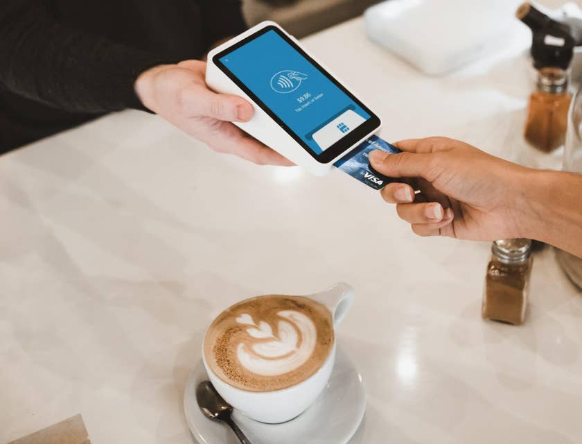 Cashier taking client's credit card coffee payment