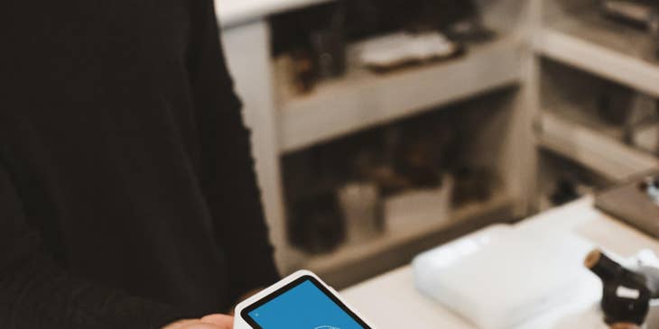 Cashier taking client's credit card coffee payment