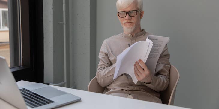 Casting Director reading the script of a specific character to determine which actor best suits the role