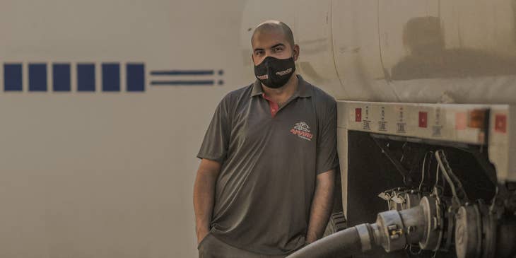 A CDL Driver loading and ensuring the truck is filled with oil before taking off for delivery.