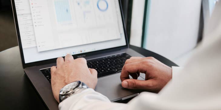 CFO reviewing the financial statements on his laptop for the organization's annual report