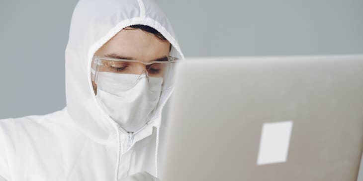 A Chemical Operator wearing a safety gear using his laptop and entering informations gathered on a database.