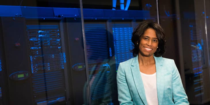 Chief Data Officer leaning on the glass wall enclosing the servers and holding a tablet