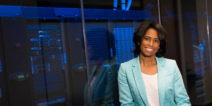 Chief Data Officer leaning on the glass wall enclosing the servers and holding a tablet