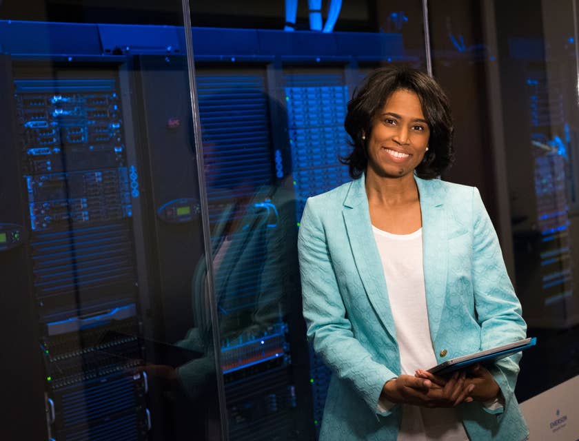 Chief Data Officer leaning on the glass wall enclosing the servers and holding a tablet