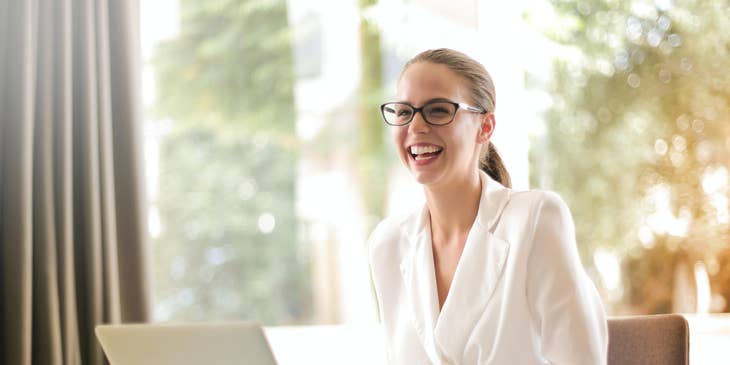 Chief Strategy Officer smiling while looking at her colleague and sitting in her office