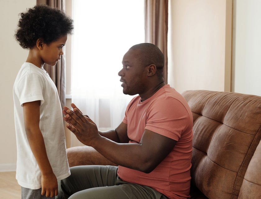 Child Protective Investigator talking to a standing child while sitting on the couch