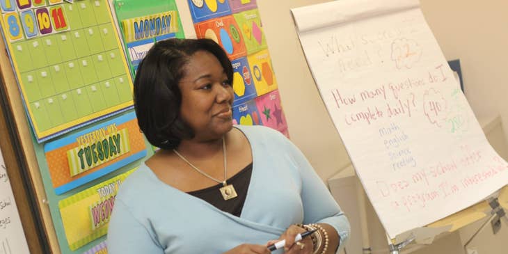 Childcare Assistant listens to students while teaching.