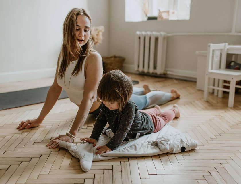 Childcare Teacher playing yoga with a toddler