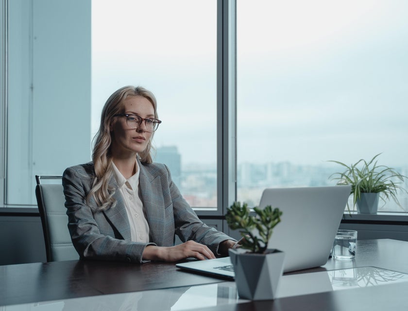 female CIO wearing eyeglasses and typing on her laptop