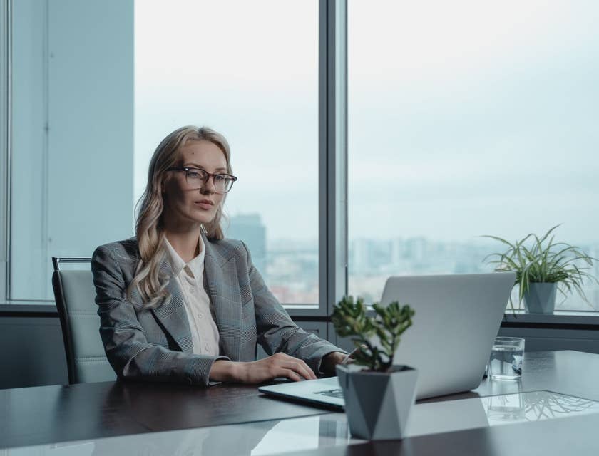 female CIO wearing eyeglasses and typing on her laptop