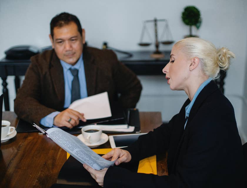 A Female Civil Rights Attorney showing a document to a client and providing legal advice.