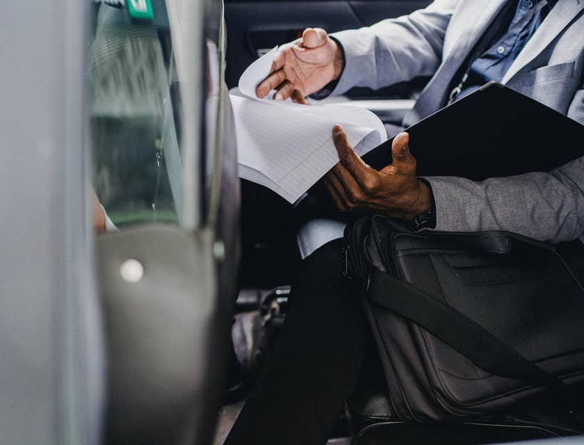 A Claims Adjuster inside a vehicle examining reports filed by claimant regarding a damaged vehicle.