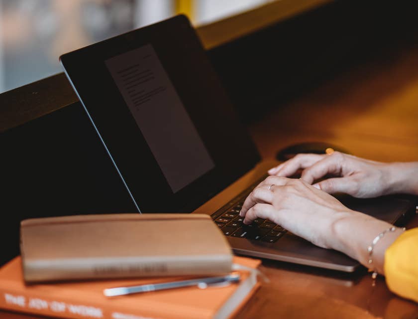 A Female Claims Specialist sitting in front of her laptop with a journal on the side of her desk.