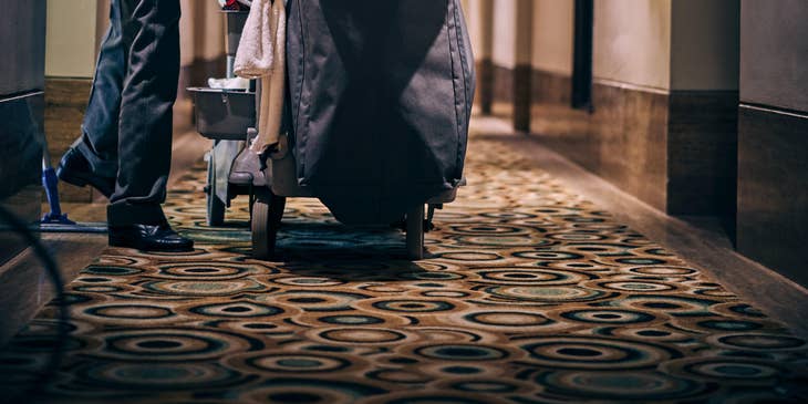 Cleaner with his utility cart in a hallway