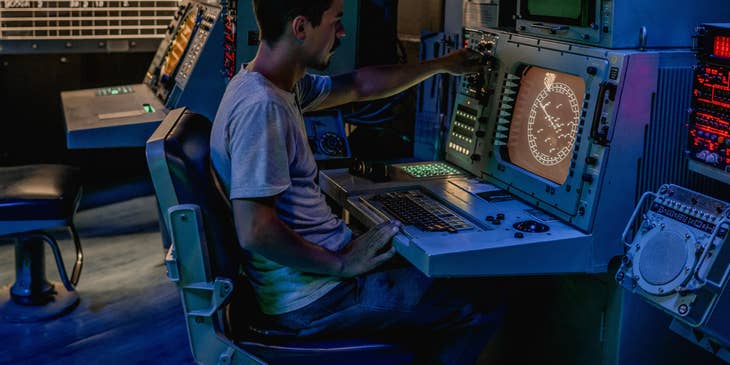 A CNC Operator working on a computer numerical controller making sure it is working properly and in accordance with guidelines.