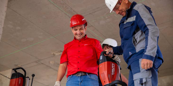 Commercial Project Manager with one of his team members trying out their driller.