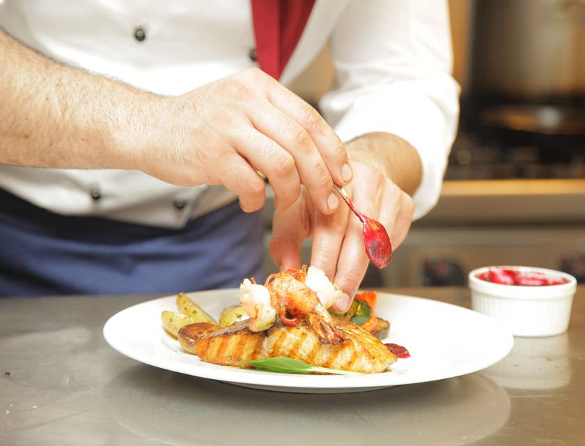Commis Chef is plating a meal as per head chef's instruction.