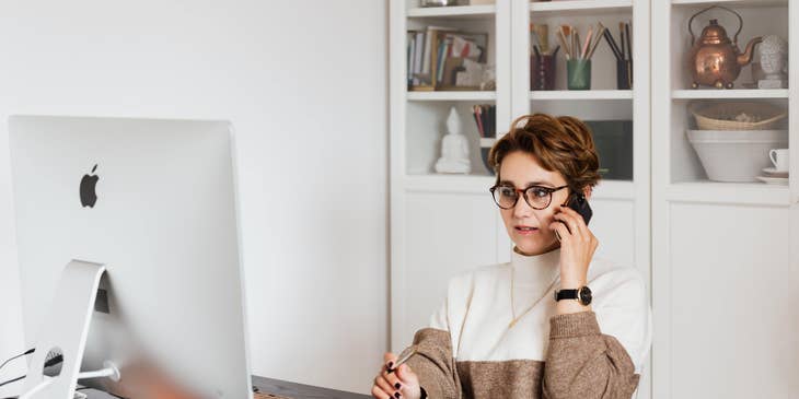 Communications Coordinator taking a phone call while constructing new marketing content