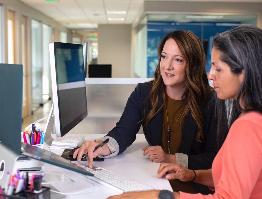 A Female Compliance Coordinator in a black blazer assessing company policies with a department head.