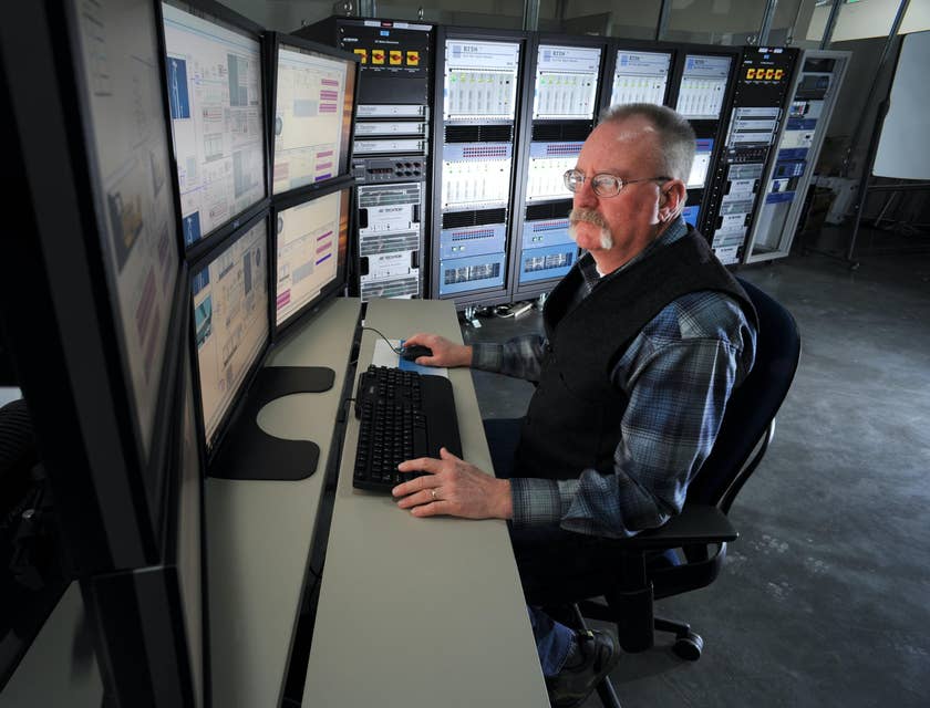 Computer Operator sitting at his workstation and monitoring the company's network performance