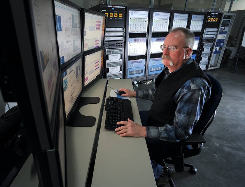 Computer Operator sitting at his workstation and monitoring the company's network performance