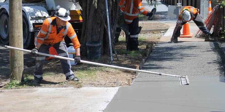 Team of Concrete Laborer finishing up concrete walkway project.