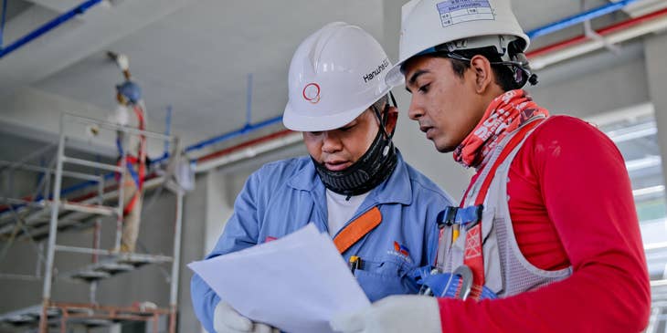 Construction Coordinator discussing project flow to his worker.