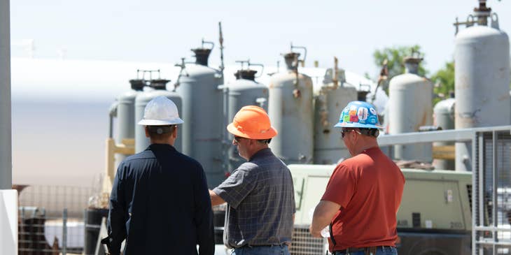 Construction Engineer having a discussion with his assistant and foreman on site