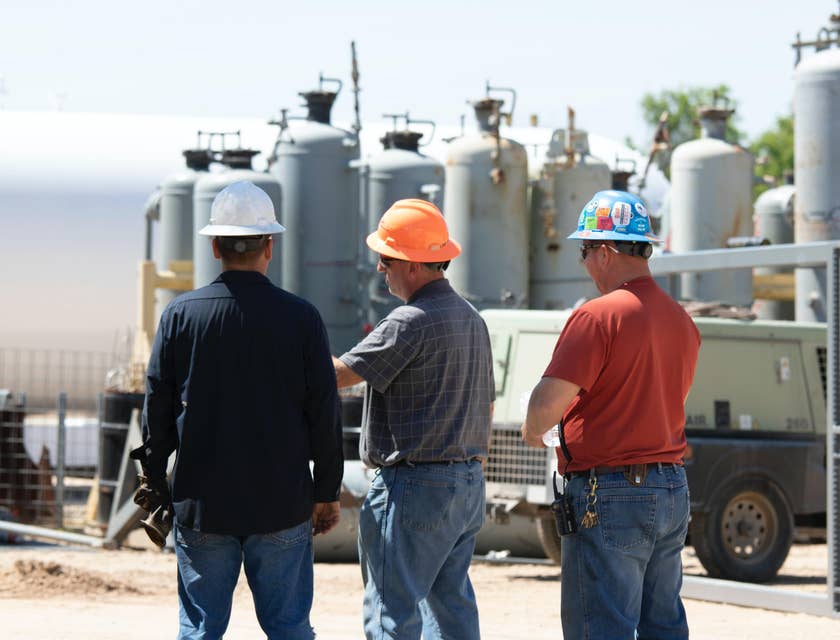 Construction Engineer having a discussion with his assistant and foreman on site