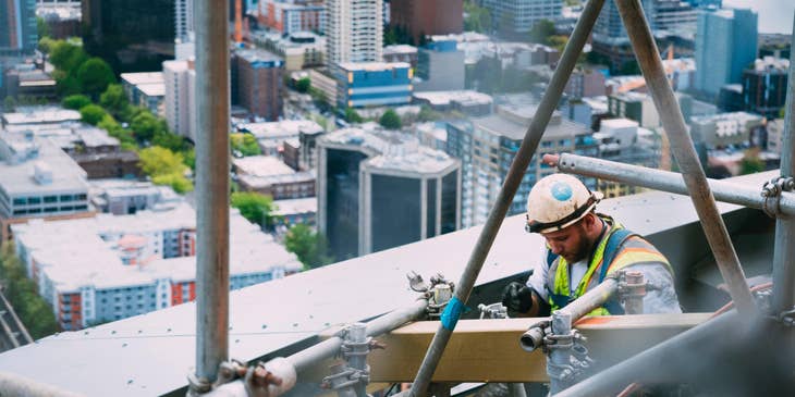 Construction Laborer preparing scaffolding for construction.