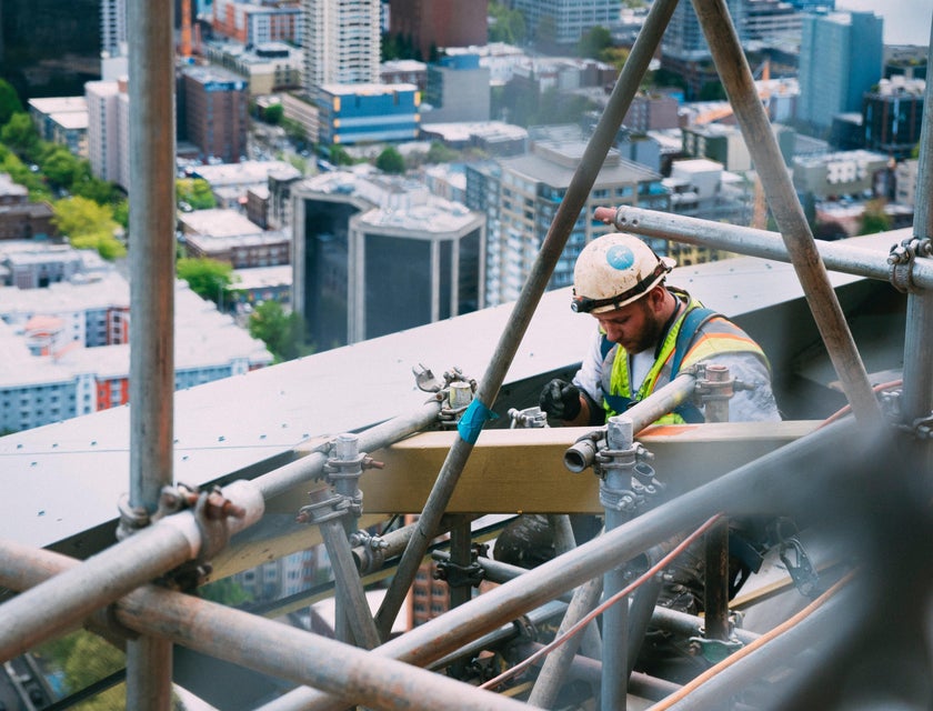 Construction Laborer preparing scaffolding for construction.