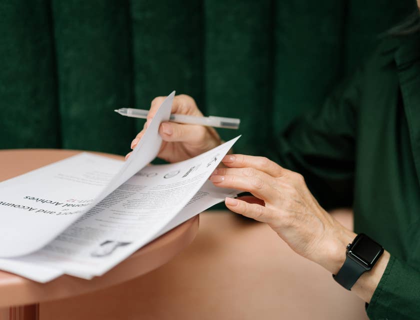 A Female Contract Analyst reviewing some contracts to ensure adherence to legal requirements by law.