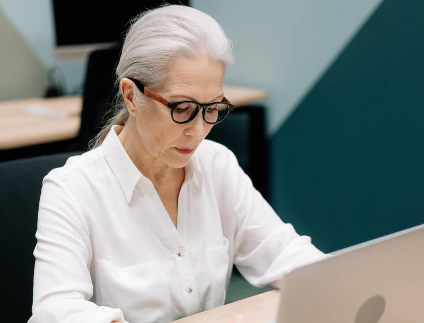 A Female Contract Specialist drafting contracts for clients on her laptop.