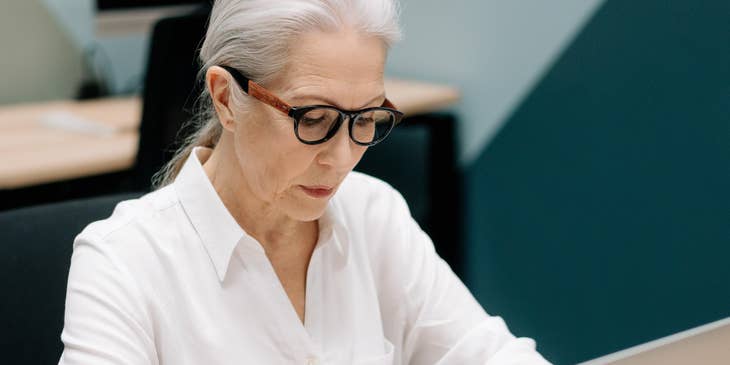 A Female Contract Specialist drafting contracts for clients on her laptop.