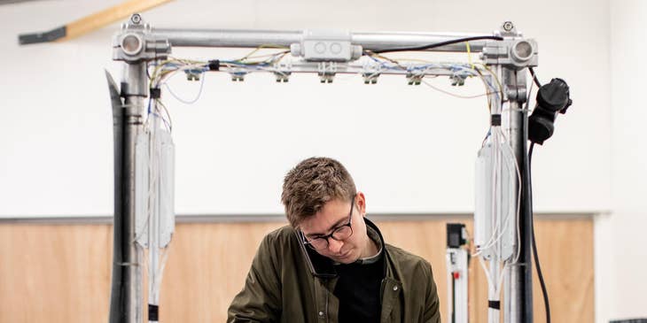 A Controls Engineer working holding a keyboard troubleshooting issues with hardware.