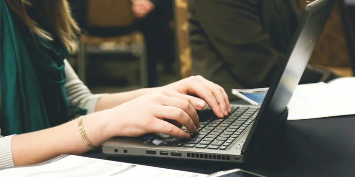 A copywriter typing on a computer.