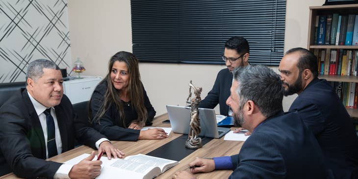 A Corporate Lawyer present in a meeting evaluating and ensuring compliance with legal regulations of new business partnership.
