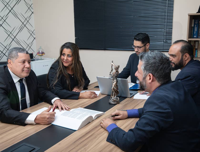 A Corporate Lawyer present in a meeting evaluating and ensuring compliance with legal regulations of new business partnership.