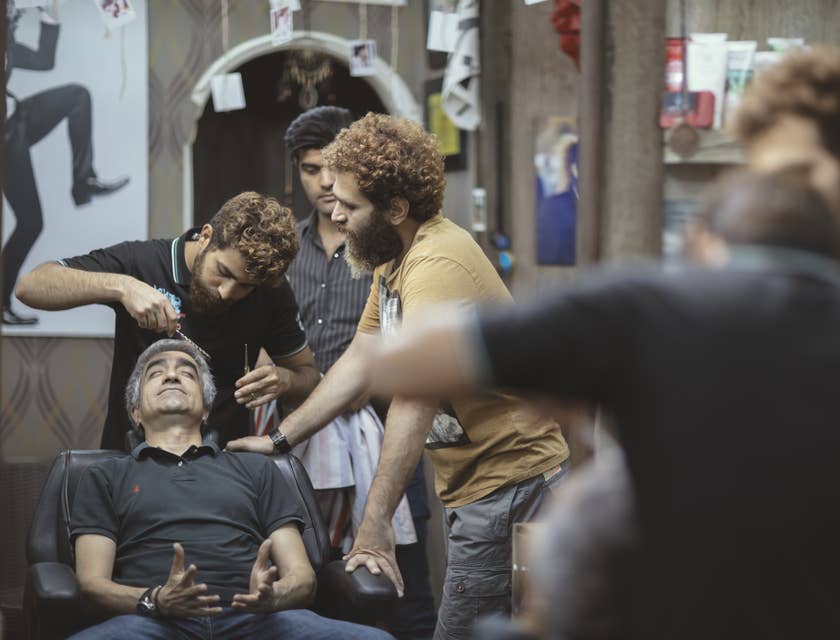 Cosmetology Instructor show student how to properly trim men's hair in a barbershop