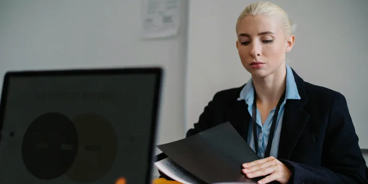 A county clerk looking at a paperwork on-hand while sitting on her workstation.