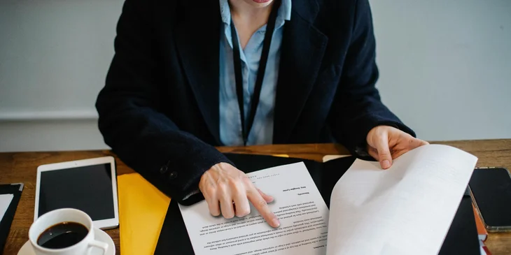A criminal analyst reviewing a criminal report before passing it.